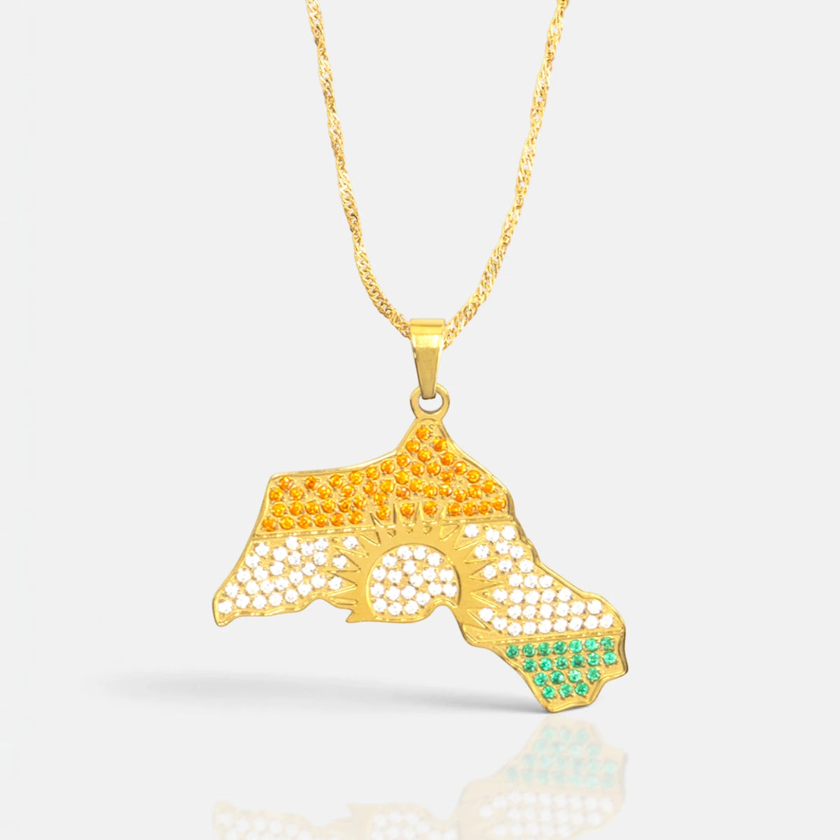Kurdistan necklace for women in 18K gold, map of Kurdistan pendant with red, white and green zirconia around the sun, fine wave chain, close-up of the pendant on grey with reflection