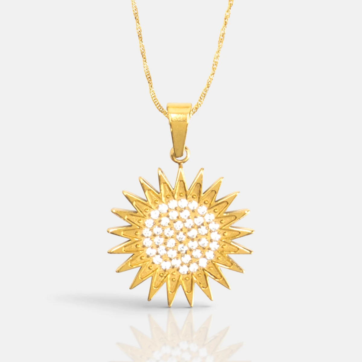 Kurdistan necklace for women in 18K gold, Kurdish sun pendant with 21 rays and clear zirconia, fine wave chain, close-up of the pendant on grey with reflection