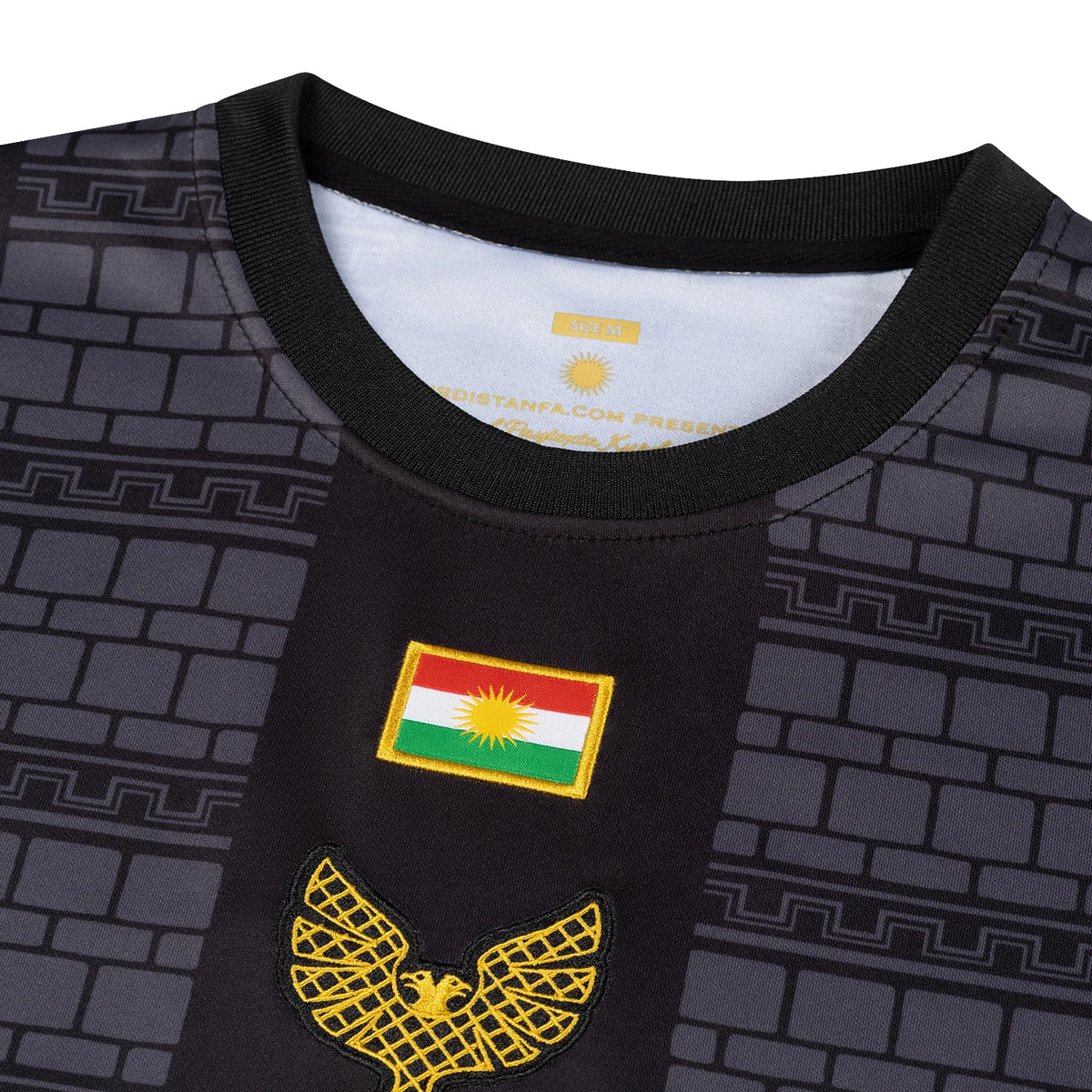 Gros plan du drapeau du Kurdistan brodé et de l aigle doré d Amed sur le maillot Amed Kurdistan extérieur noir et or