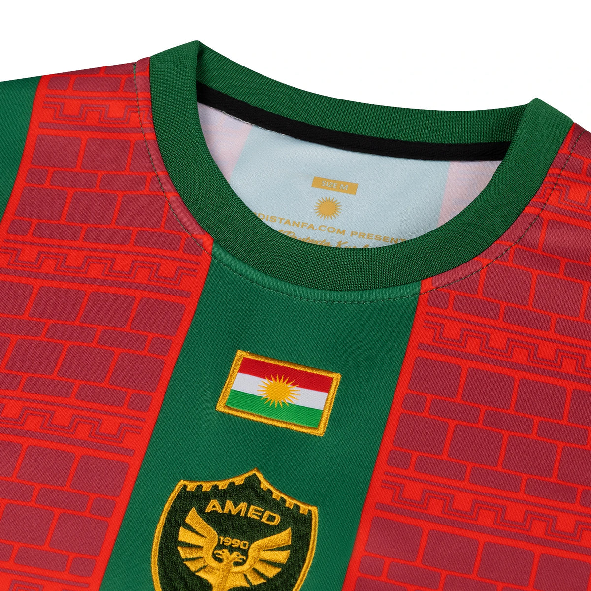 Gros plan du drapeau du Kurdistan brodé et de l écusson aigle doré d Amed sur le maillot Amed Kurdistan domicile vert et rouge